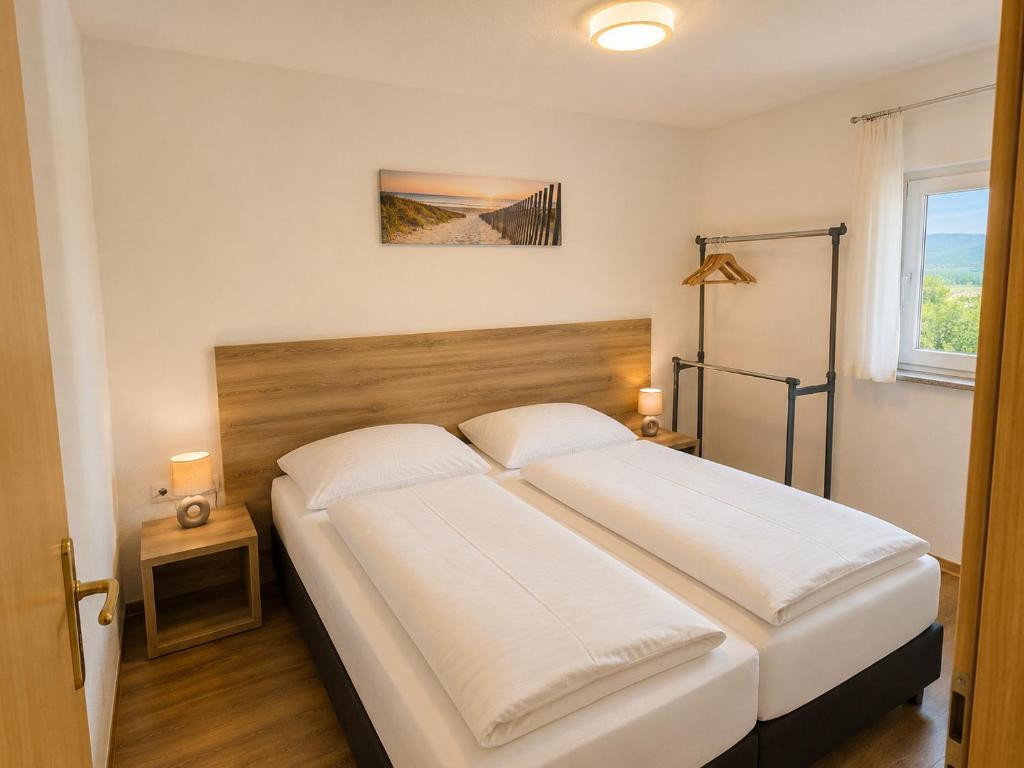 a bedroom with a large bed with two white pillows at Grabovica Sobe-Blue Lake Luxury Rooms in Grabovica
