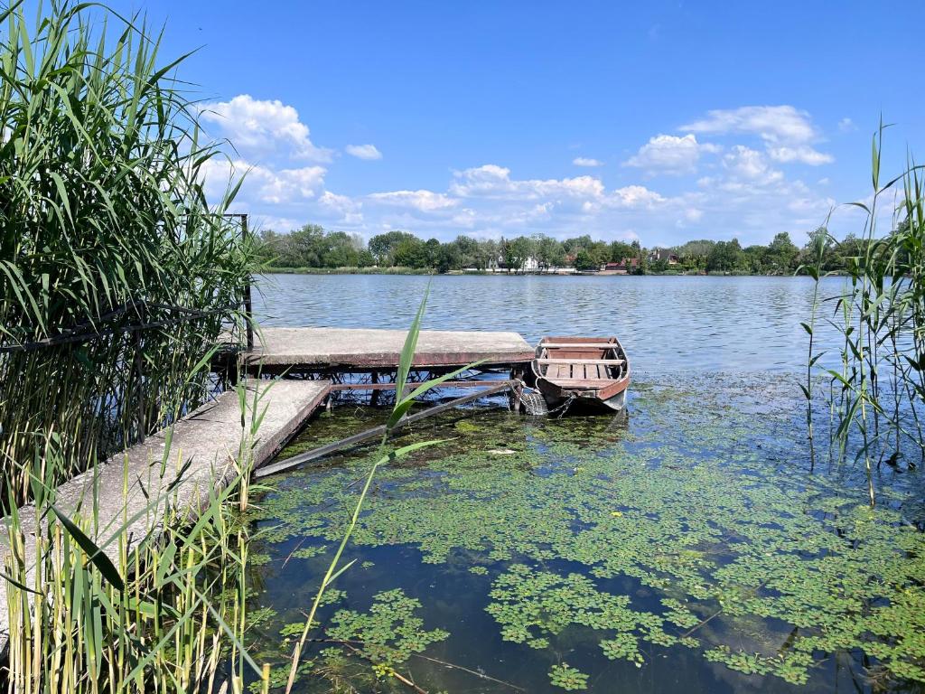 a boat sitting on the water next to a dock at Keszeg house in Szigetbecse