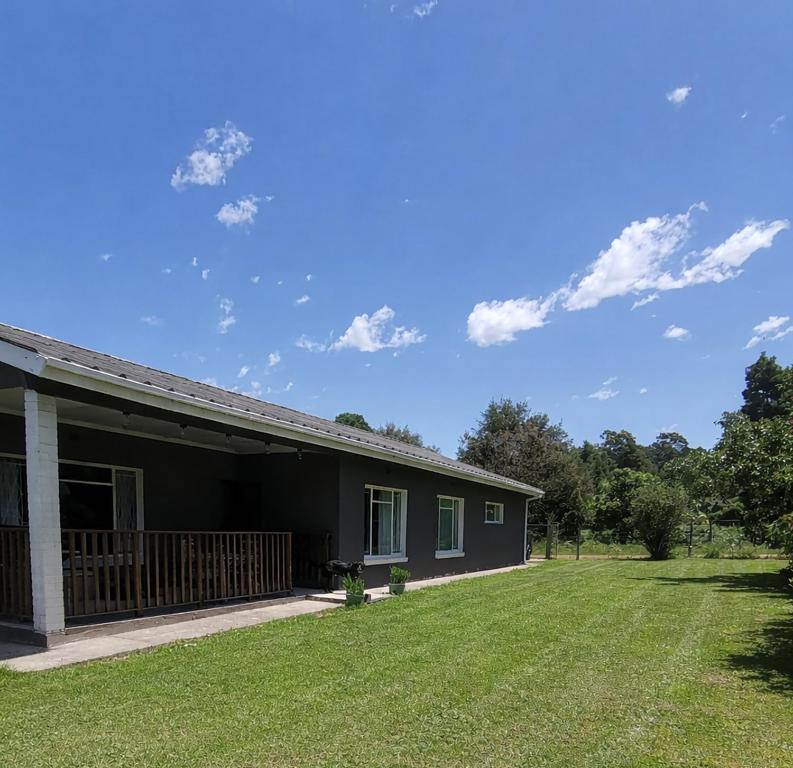 a black house with a yard in front of it at Storms River Family Accommodation in Stormsrivier
