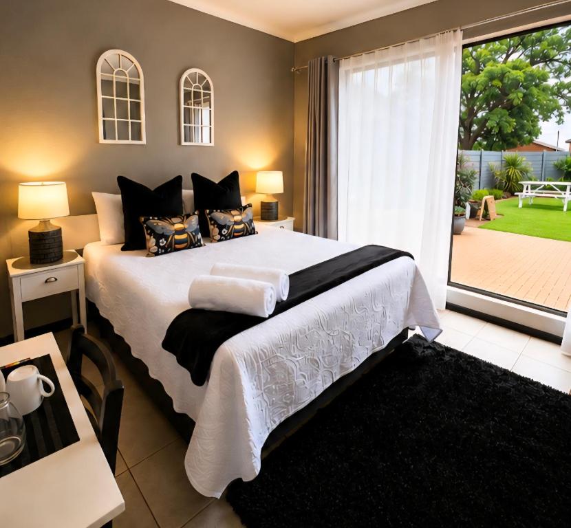 a bedroom with a large bed and a large window at Zhantique Guest House 2- Unit 4 in Boksburg