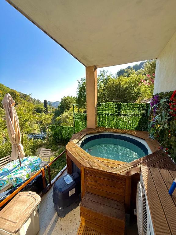 a hot tub on a patio with a view of a hill at La maison des Huskys in Sasso di Bordighera