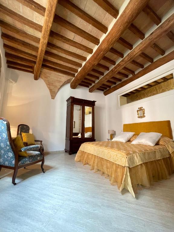 a bedroom with a large bed and a chair at Pinturicchio Luxury Suite in Perugia