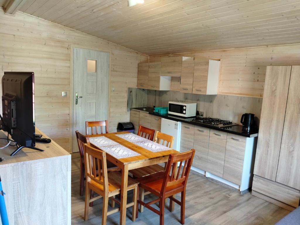 a kitchen with a table and chairs in a room at Pod starą chatą 2 in Wicie