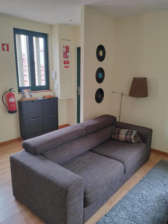 a gray couch in a living room with a window at Music Houses T3 in Espinho
