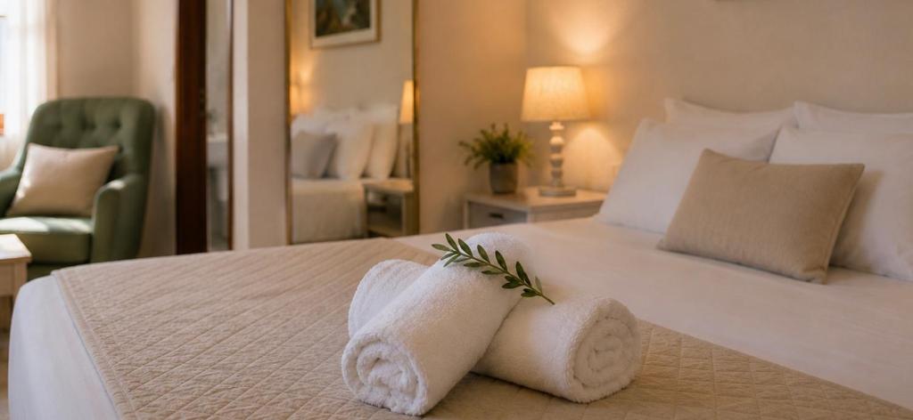 a bedroom with a white bed with towels on it at Knossos Breeze in Sitia