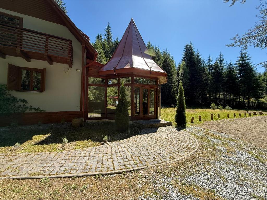 a house with a brick walkway in front of it at Red Lake Inn in Gheorgheni