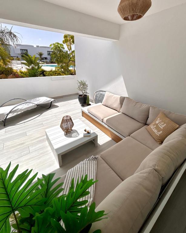 a living room with a couch and a table at Oasis in paradise with pool in La Oliva