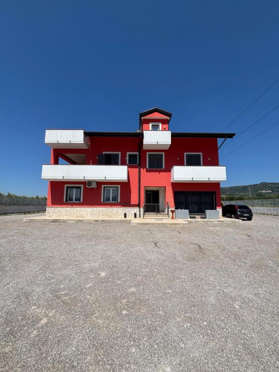 a red building with a car parked in front of it at Red House in Montecorvino Rovella