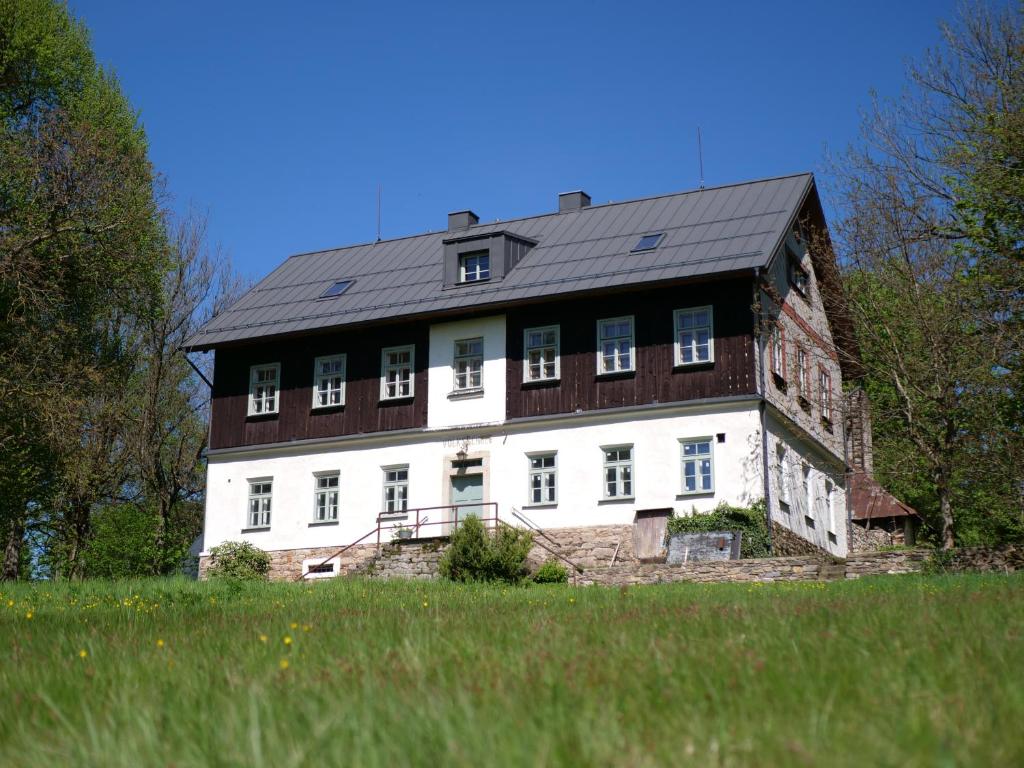 a large white house with a black roof at Škola Kačerov in Zdobnice