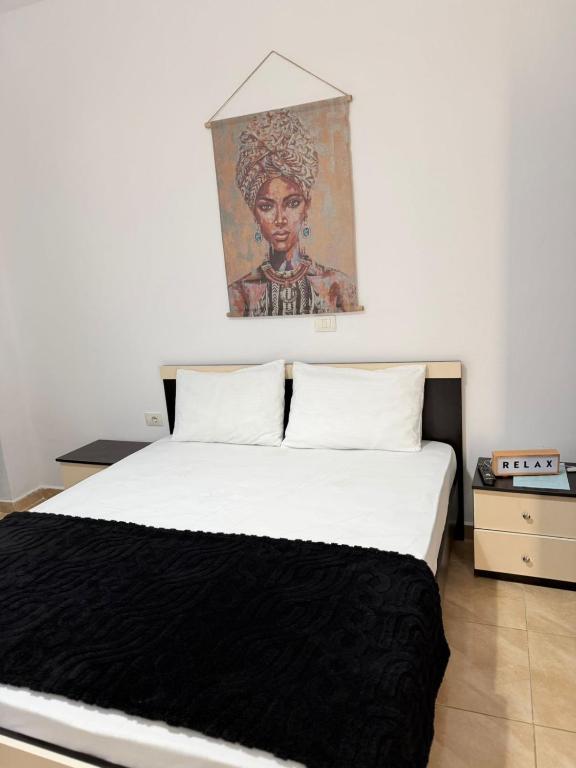 a bedroom with a bed with a painting on the wall at Apartments Gigu in Ksamil