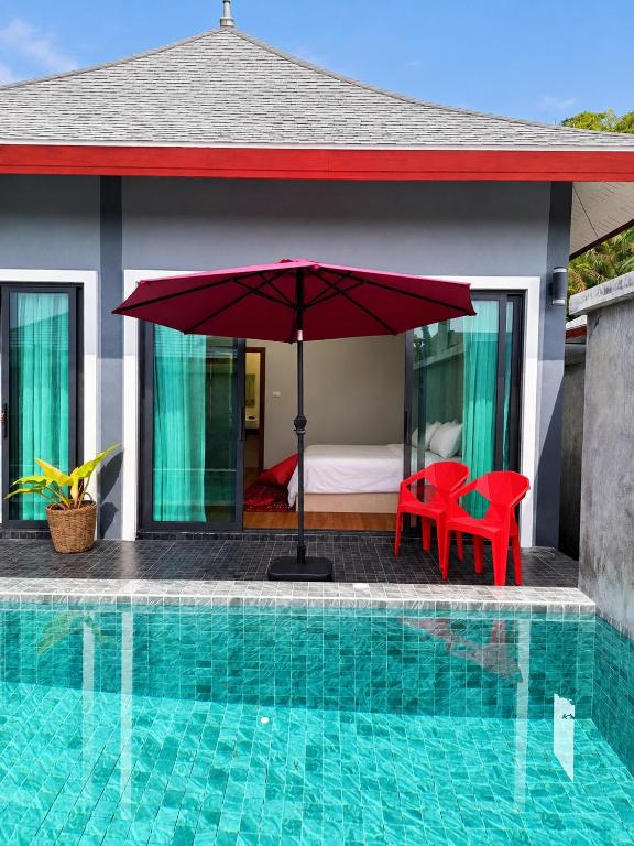 a resort with a pool and a bed and an umbrella at Villa Escape Aonang Krabi in Krabi