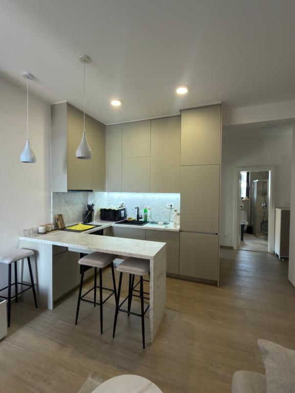 a kitchen with a large white counter and stools at Zenith Lux Apartment Beachfront & Parking in Bijela