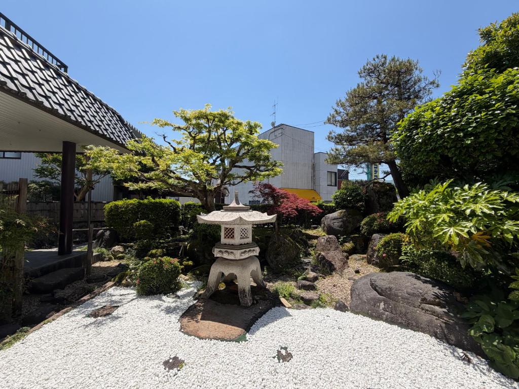 a garden with a stone table in the middle at 勝山恐竜博物館まで車で10分最大10名様ふとん屋の宿 悦 in Katsuyama
