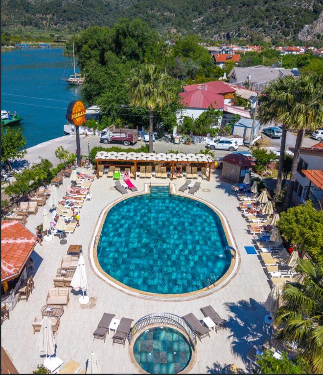 an overhead view of a swimming pool with chairs and umbrellas at Portakal Hotel Dalyan in Dalyan