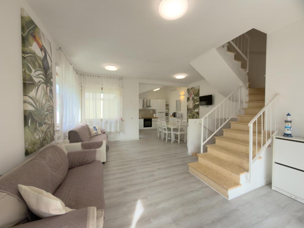 a living room with a couch and a staircase at Villa Martina in Fregene