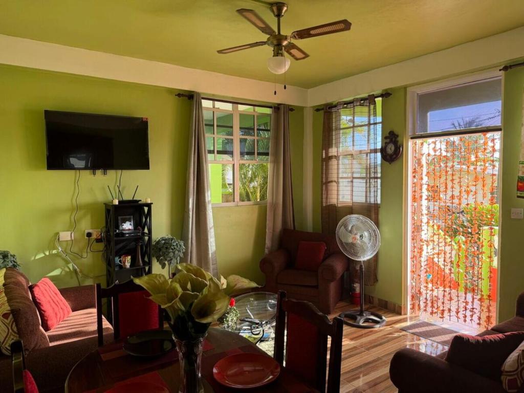 a living room with green walls and a ceiling fan at 2BR Guest Home - Dominica in Pointe Michel