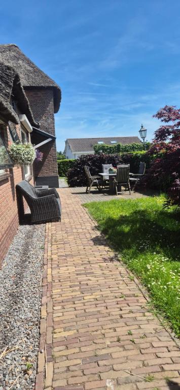 a brick walkway with benches on the side of a house at Betuwe Huisje in Meteren