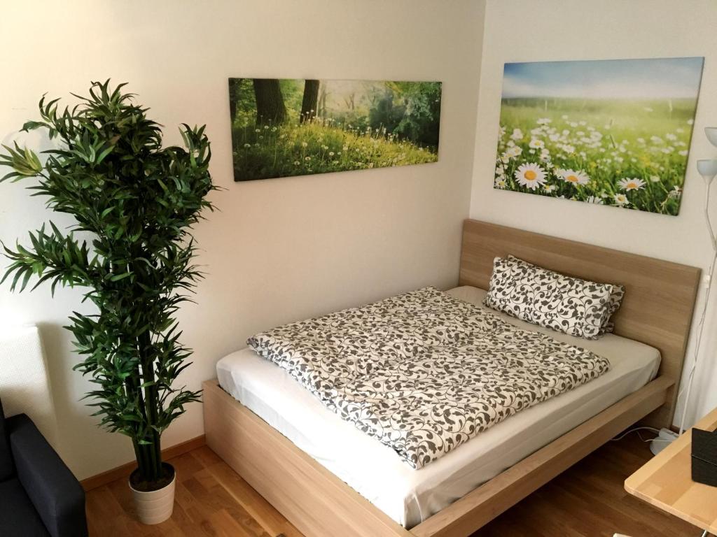 a bed in a room with a plant at Apartment Flowerside in Regensburg