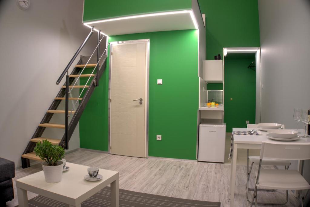 ブダペストにあるHILD-1 Apartmentsの緑の壁と階段のあるリビングルーム