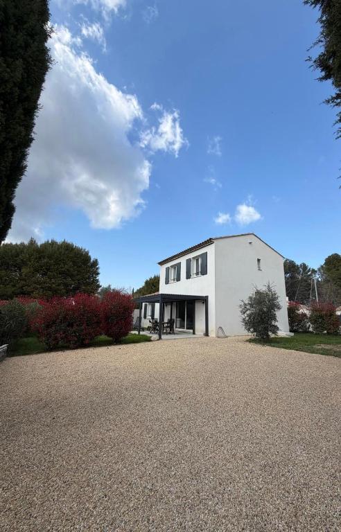 a white building with a driveway in front of it at Maison Eguilles in Éguilles