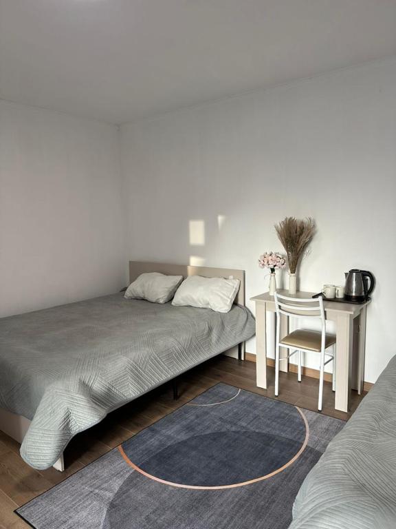 a bedroom with a bed and a table with a chair at Tosor Guest House Medet in Tossor