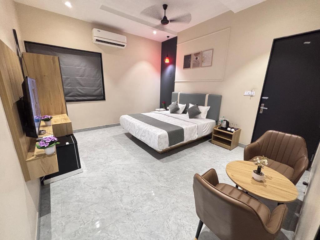 a hotel room with a bed and a table and chairs at Hotel Stayvilla Raipur in Raipur