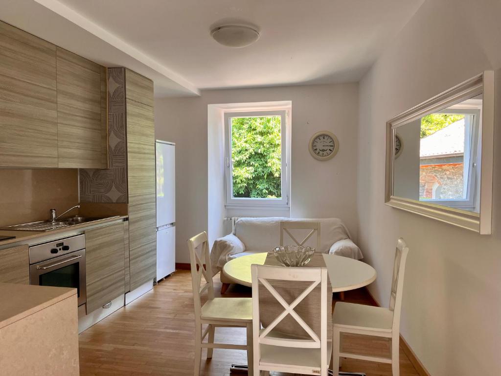 a kitchen and dining room with a table and chairs at Vicolo Carate in Gravedona