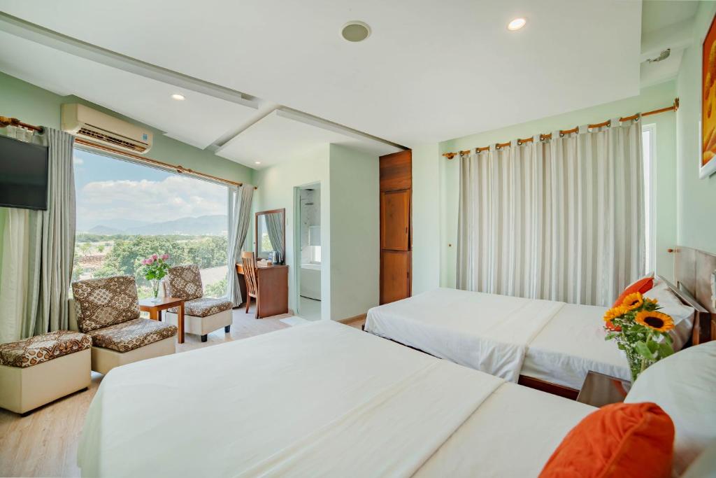 a hotel room with two beds and a window at Art Deluxe Hotel in Nha Trang