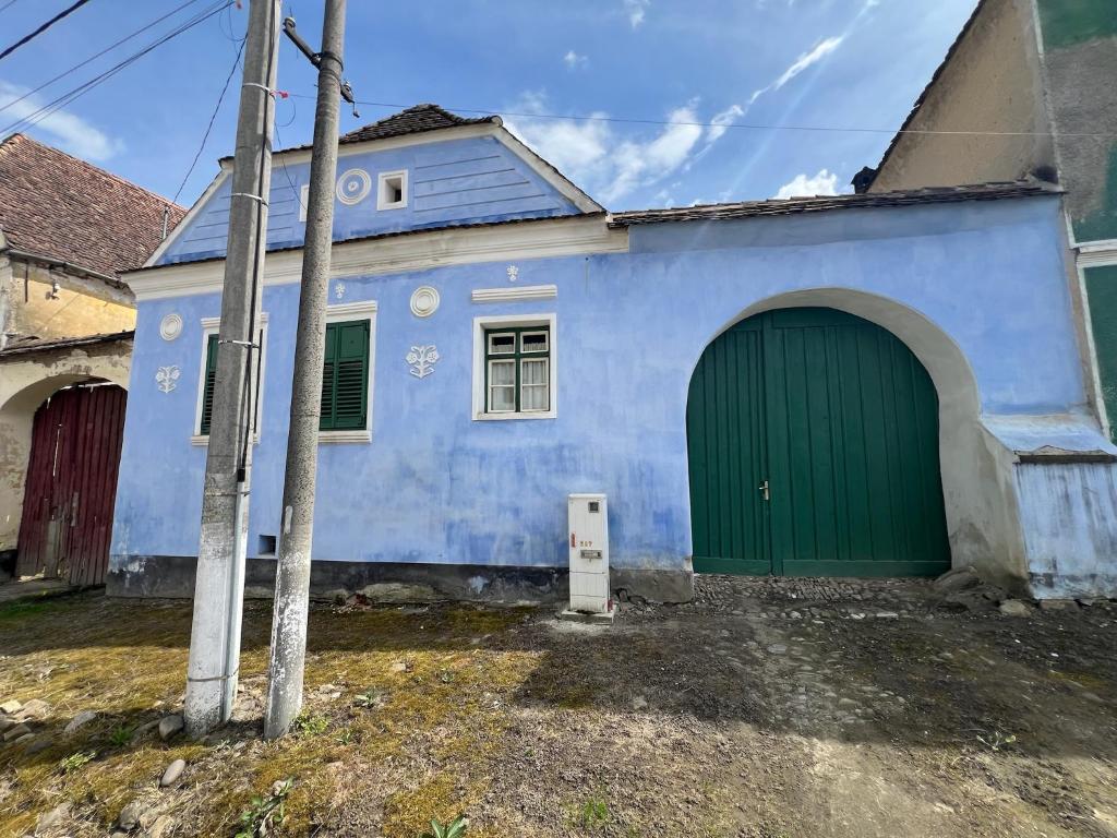 a blue house with a green door in front at Archita 155 in Archita