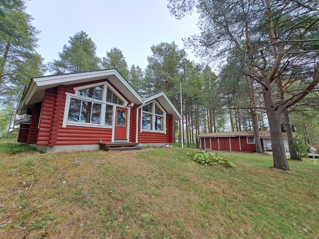 a red tiny house in the middle of a yard at Villa Kalkonniemi in Kemijärvi
