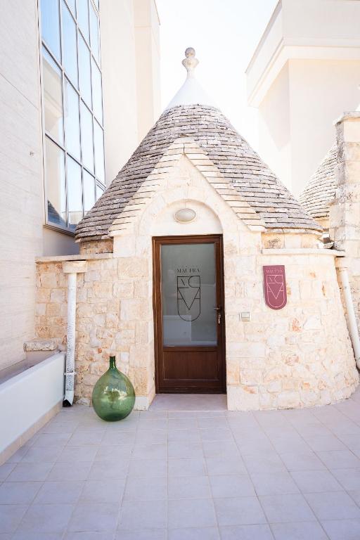 a large green vase sitting in front of a door at Trullo Màufra in Locorotondo