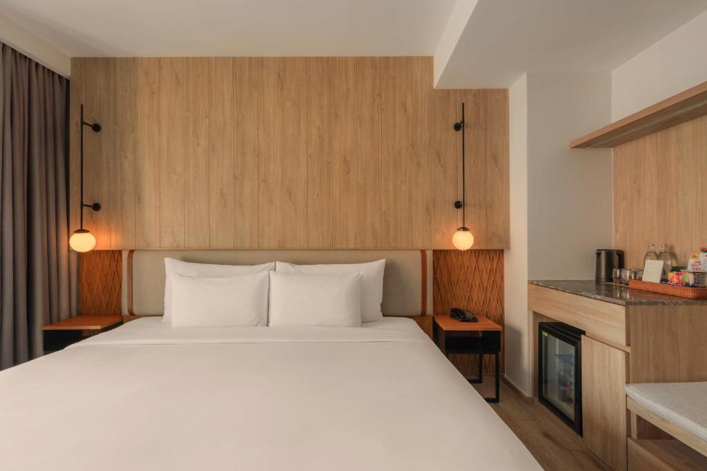A bedroom with a king-size bed and a compact kitchenette or minibar along one wall.