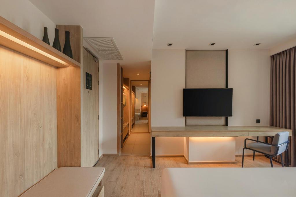 A room corner with a built-in desk, chair, television and a narrow entry corridor.