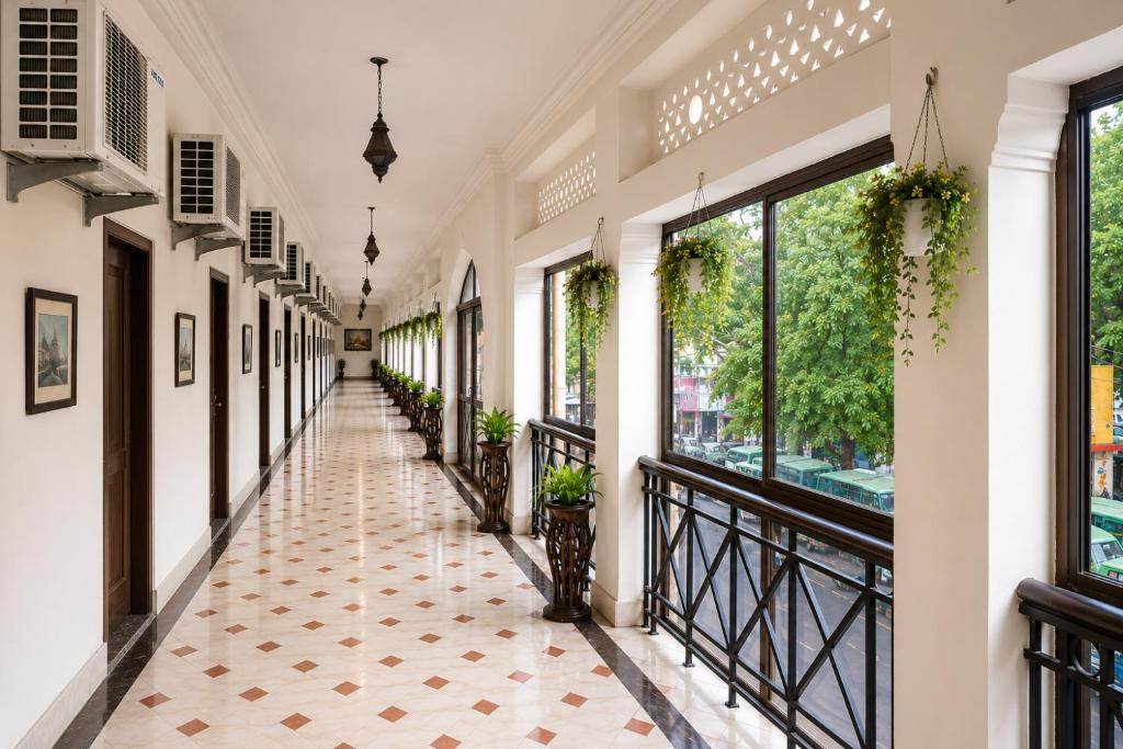 a hallway of a building with windows and a tiled floor at Central Hotel in Lucknow