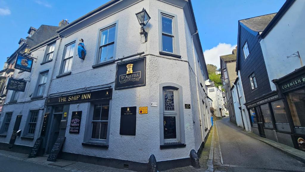 a white building on the corner of a street at The Ship Inn Looe in Looe