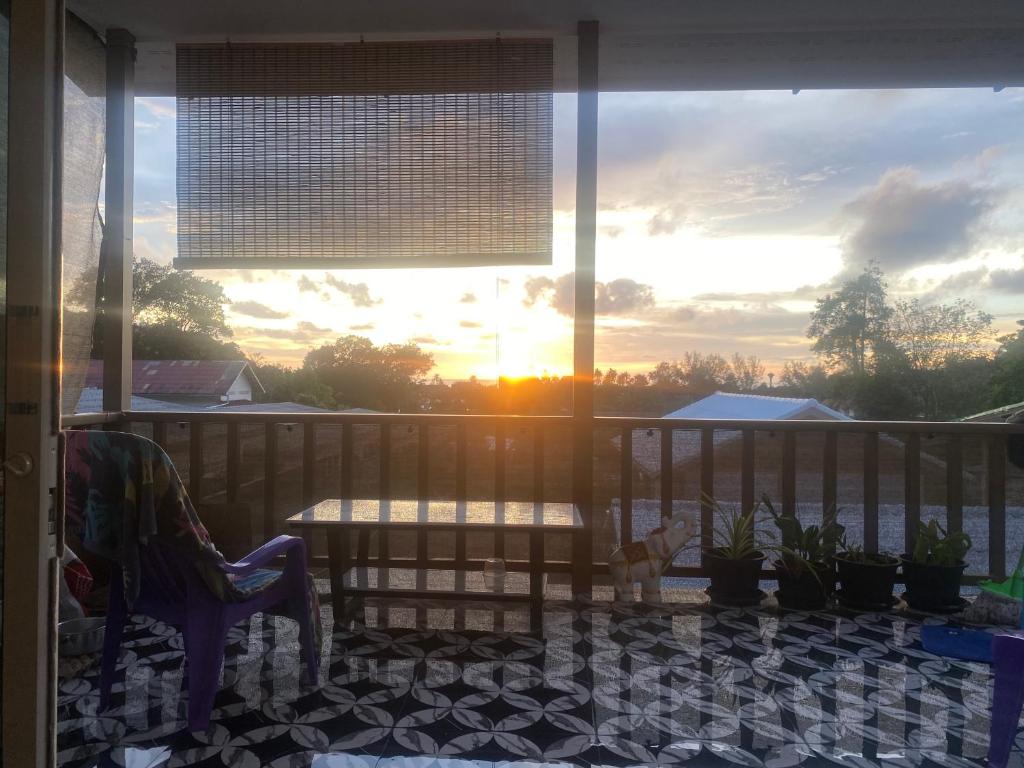 a screened porch with a table and chairs and the sunset at Ocean View Tuggi Klong Prao in Klong Prao Beach