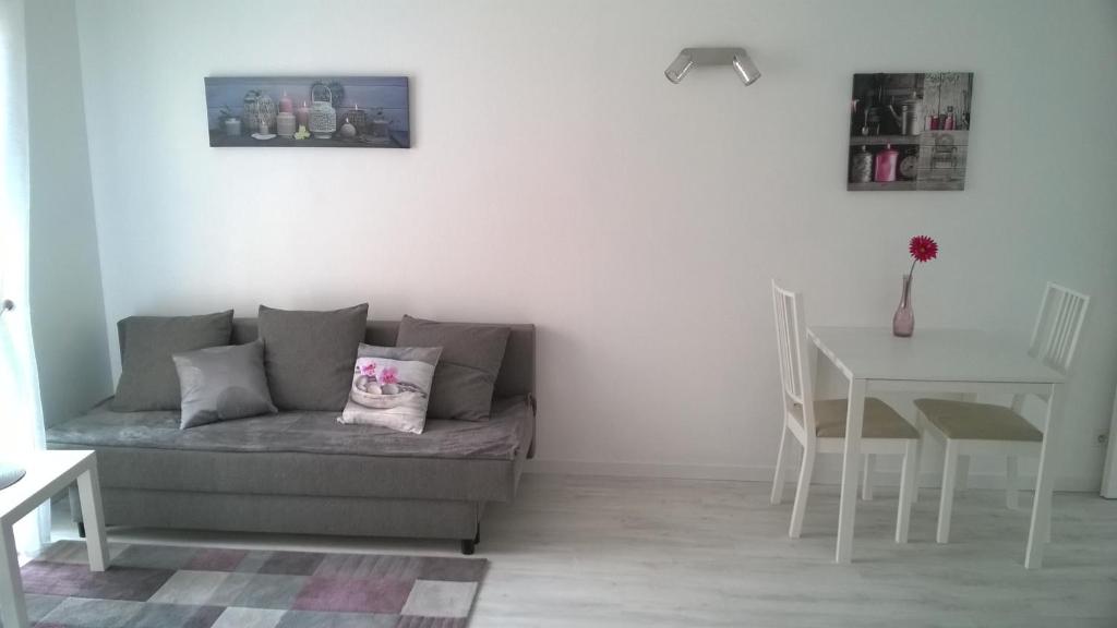 uma sala de estar com um sofá e uma mesa em Clos Chantegrive em Saint-Médard-en-Jalles