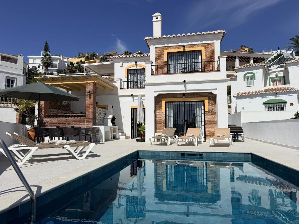 a house with a swimming pool in front of a house at Salida Del Sol in Nerja