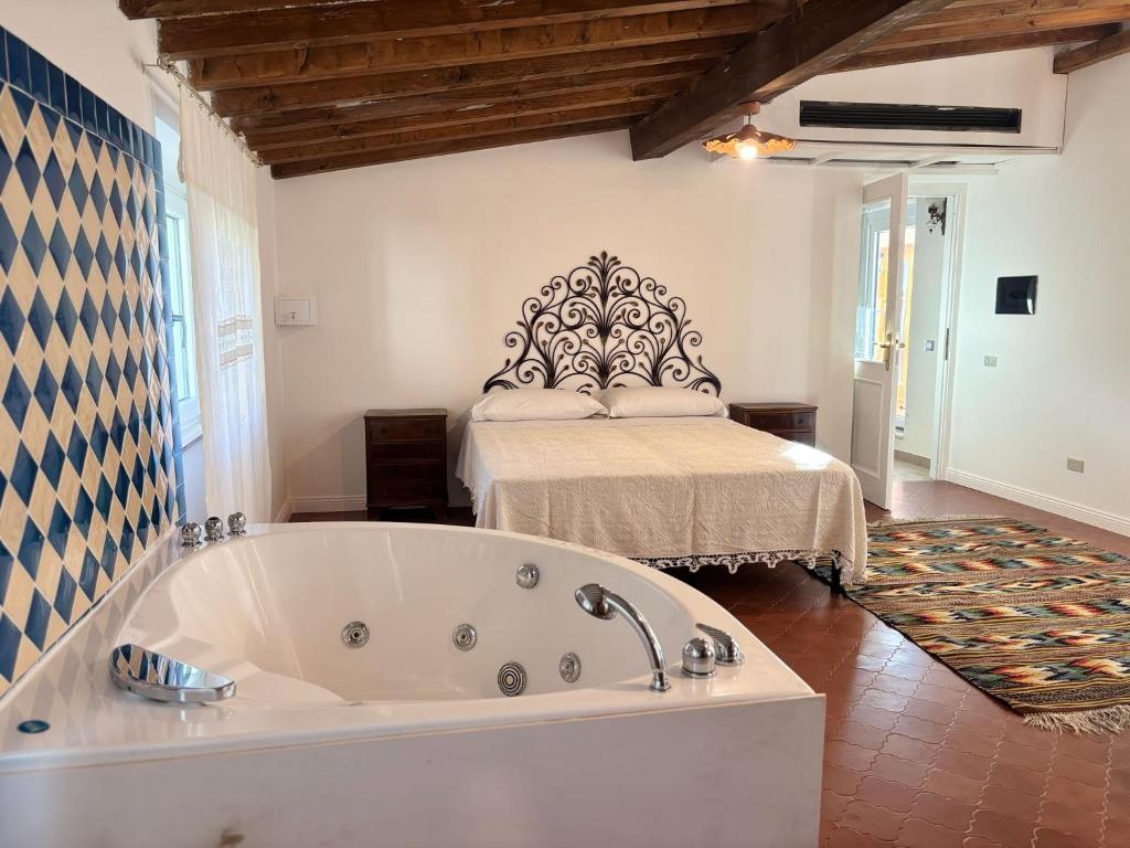 a large bath tub in a room with a bed at Relais Casa Spanu in Dorgali