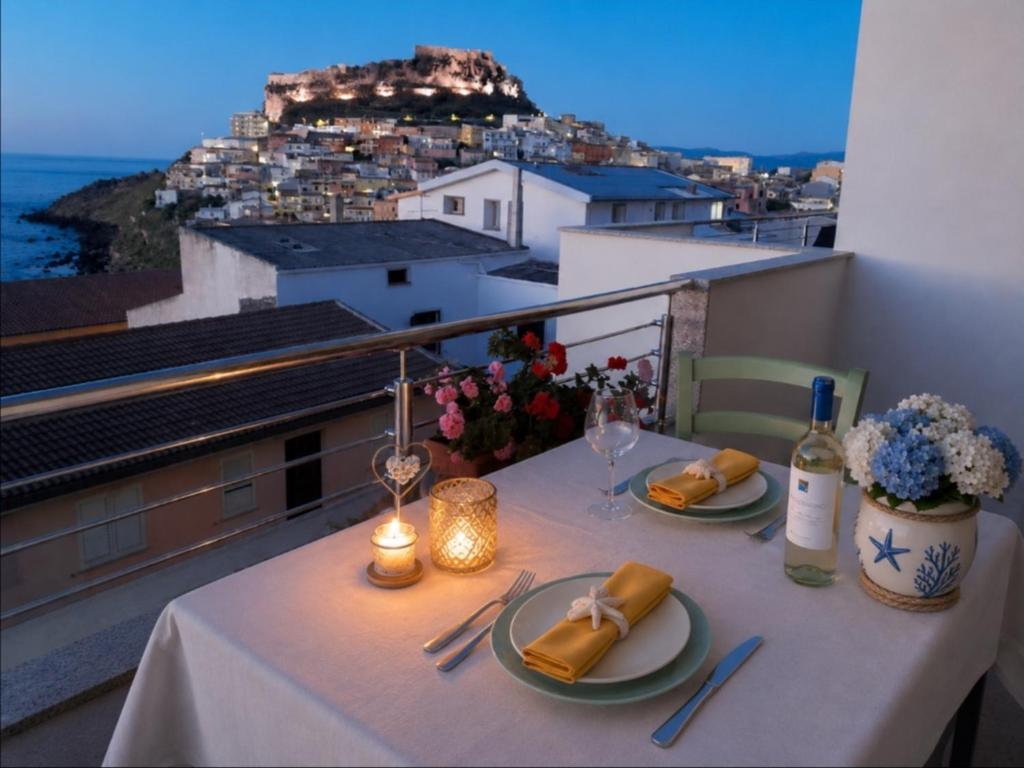 a table with plates of food and wine on a balcony at Brezza Marina & L'oasi Blu in Castelsardo