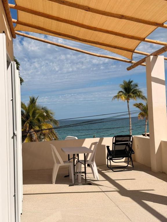 a patio with a table and chairs and the ocean at Ocean View Studio Near Los Barriles in Buenavista