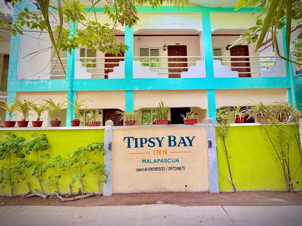 a building with a sign in front of it at Tipsy Bay Inn - Malapascua in Daanbantayan