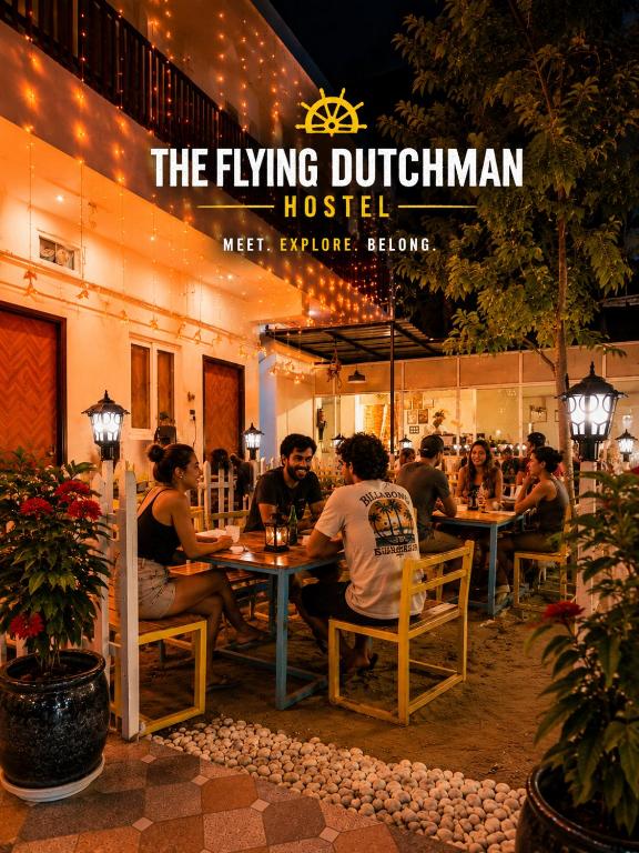 a group of people sitting at tables in a restaurant at Flying Dutchman Hostel in Varanasi