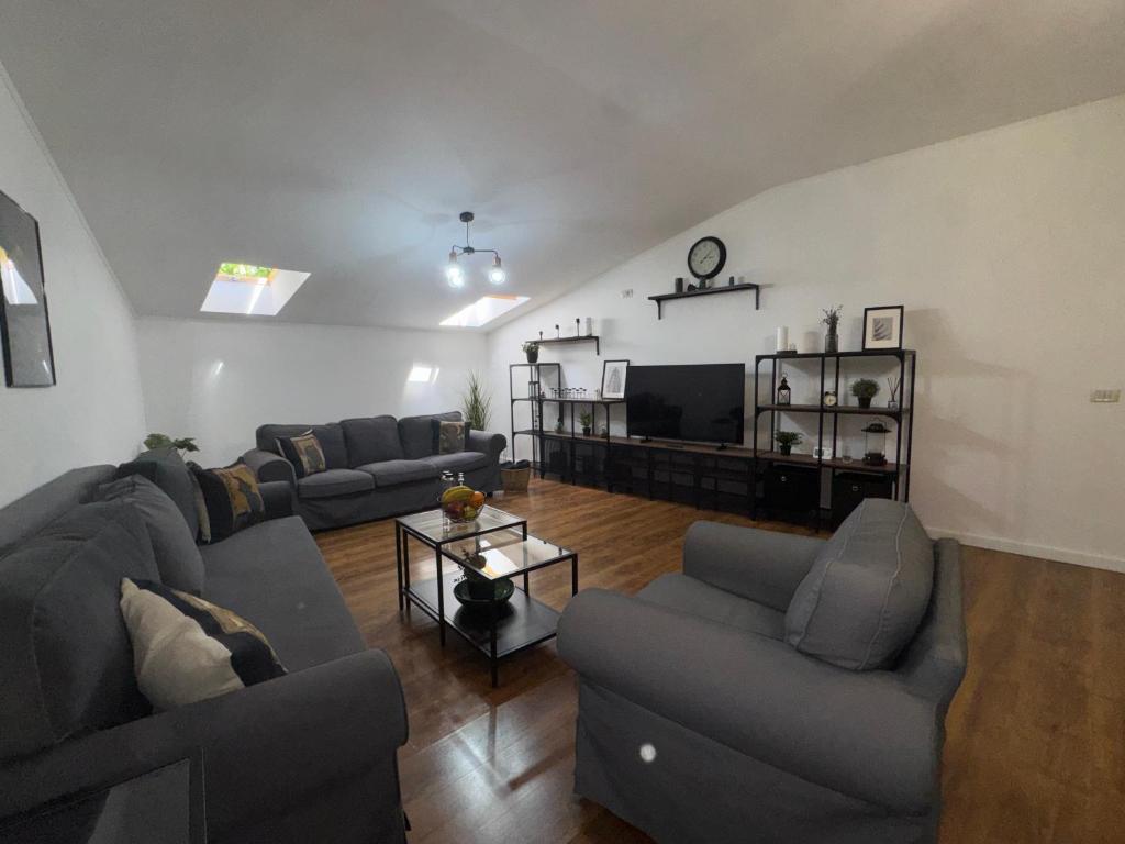 a living room with couches and a flat screen tv at Dare apartments 3 in Giurgiu