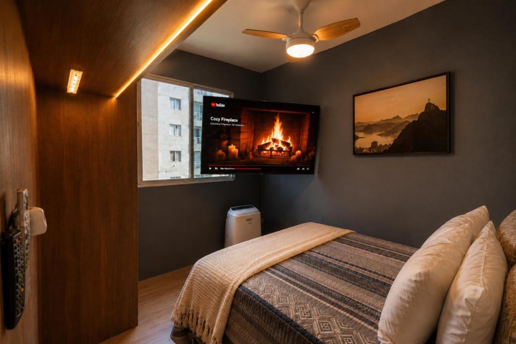 a bedroom with a bed with a tv on the wall at PierMauá-Rooftop, Vista, Piscina, Sauna, VLT & Maracanã in Rio de Janeiro