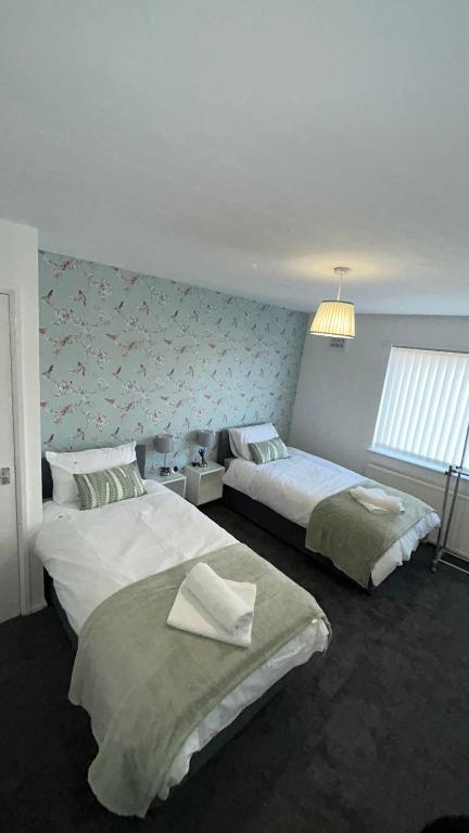 a bedroom with two beds and a window at Contractors , holiday house, free parking , sleeps 5 in Knowsley