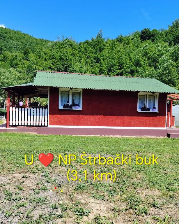 a small red house with a green roof at Mubina Apartman in Ćukovi