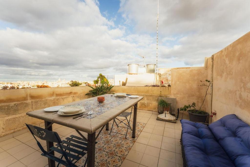 a patio with a table and chairs on a balcony at 3BR Townhouse with Private Rooftop in Bormla in Taʼ Penza