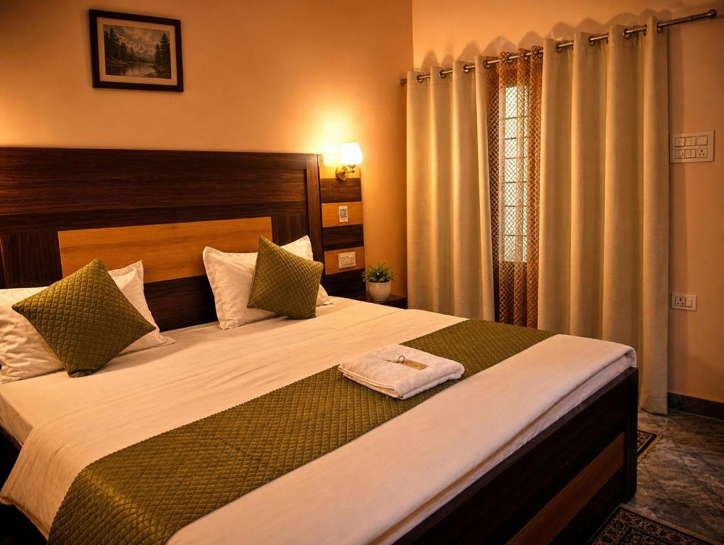 a bedroom with a large bed with a towel on it at Geetanjali Palace Hotel & Restaurant in Rudraprayāg