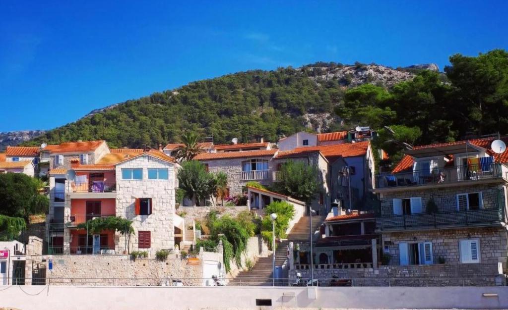 eine Gruppe von Häusern vor einem Berg in der Unterkunft Accommodation Stella Mare in Bol